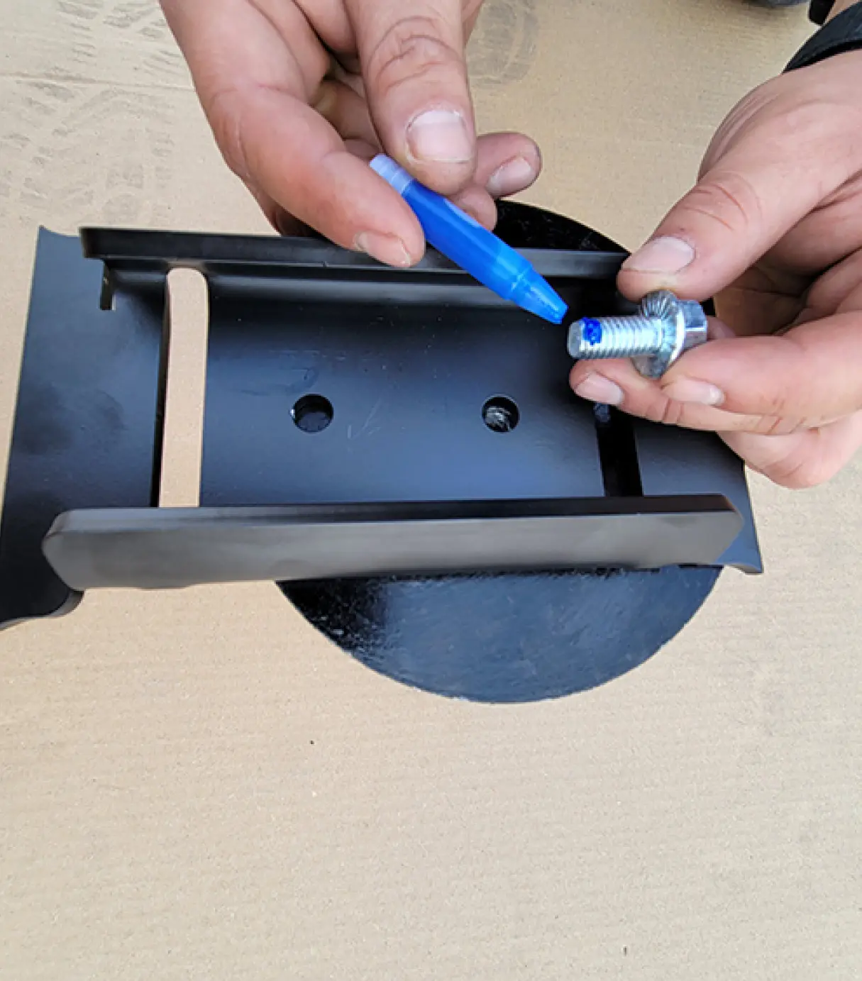 Blue Loctite being applied to bolt