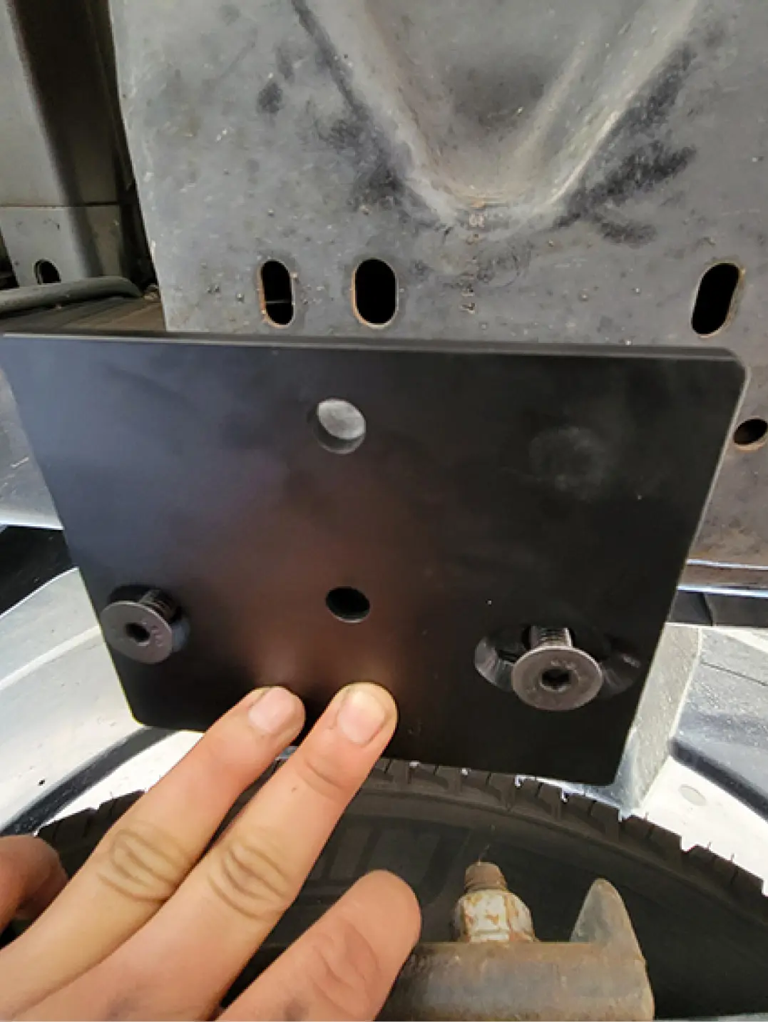two countersunk bolts for the top bracket were coated with Loctite and threaded into existing holes used to secure the factory bump stops that were previously removed
