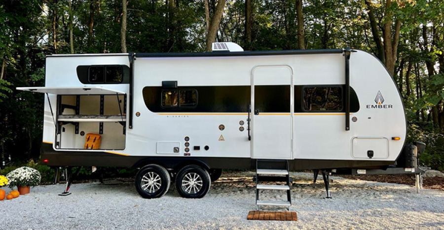 RV bunk/storage system opened on side of RV that is parked outdoors
