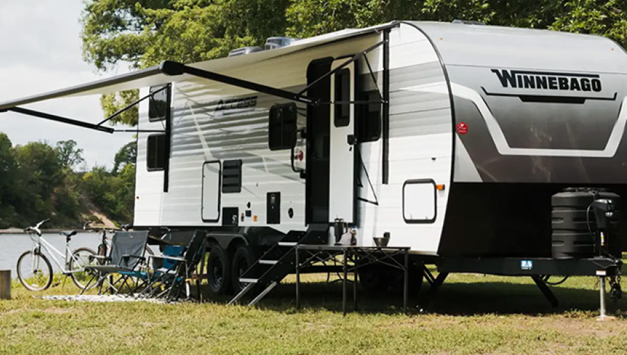 Winnebago RV parked outside with patio shade open
