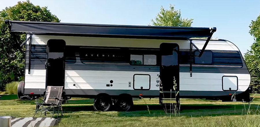 Cruiser RV Avenir parked outside on grass with patio cover open