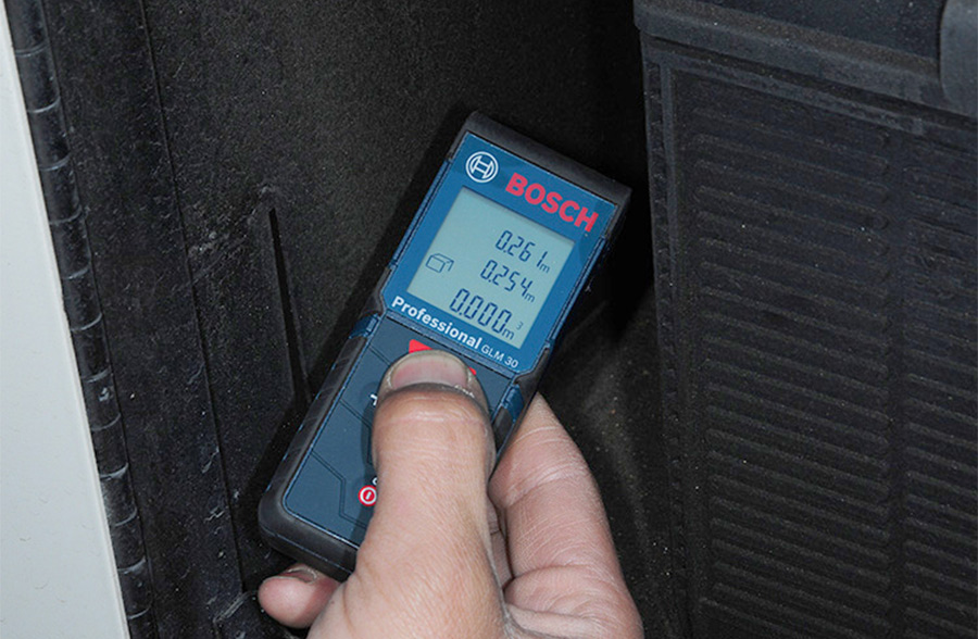 laser measuring tool being used to determine the compartment dimensions