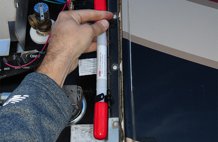 person securing a device to the metal housing of the water heater