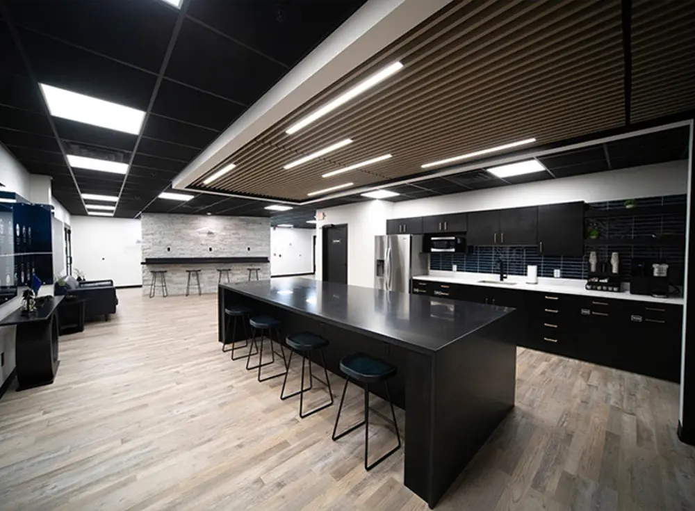 wide view of a lobby in the Jayco customer service facility featuring a large monitor displaying Jayco’s family of brands, a refreshment area with coffee, a refrigerator, a microwave, and seating areas