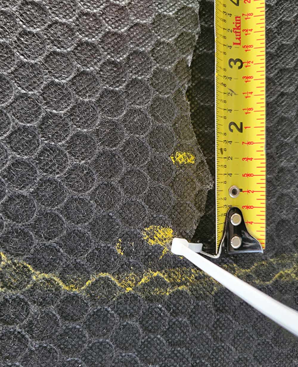 measuring tape being used to measure distance between two dots