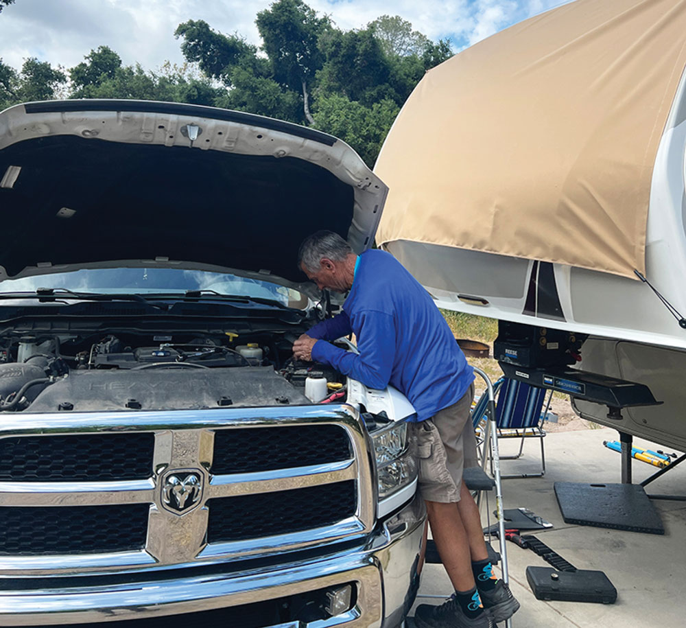 man working under the hood of a truck