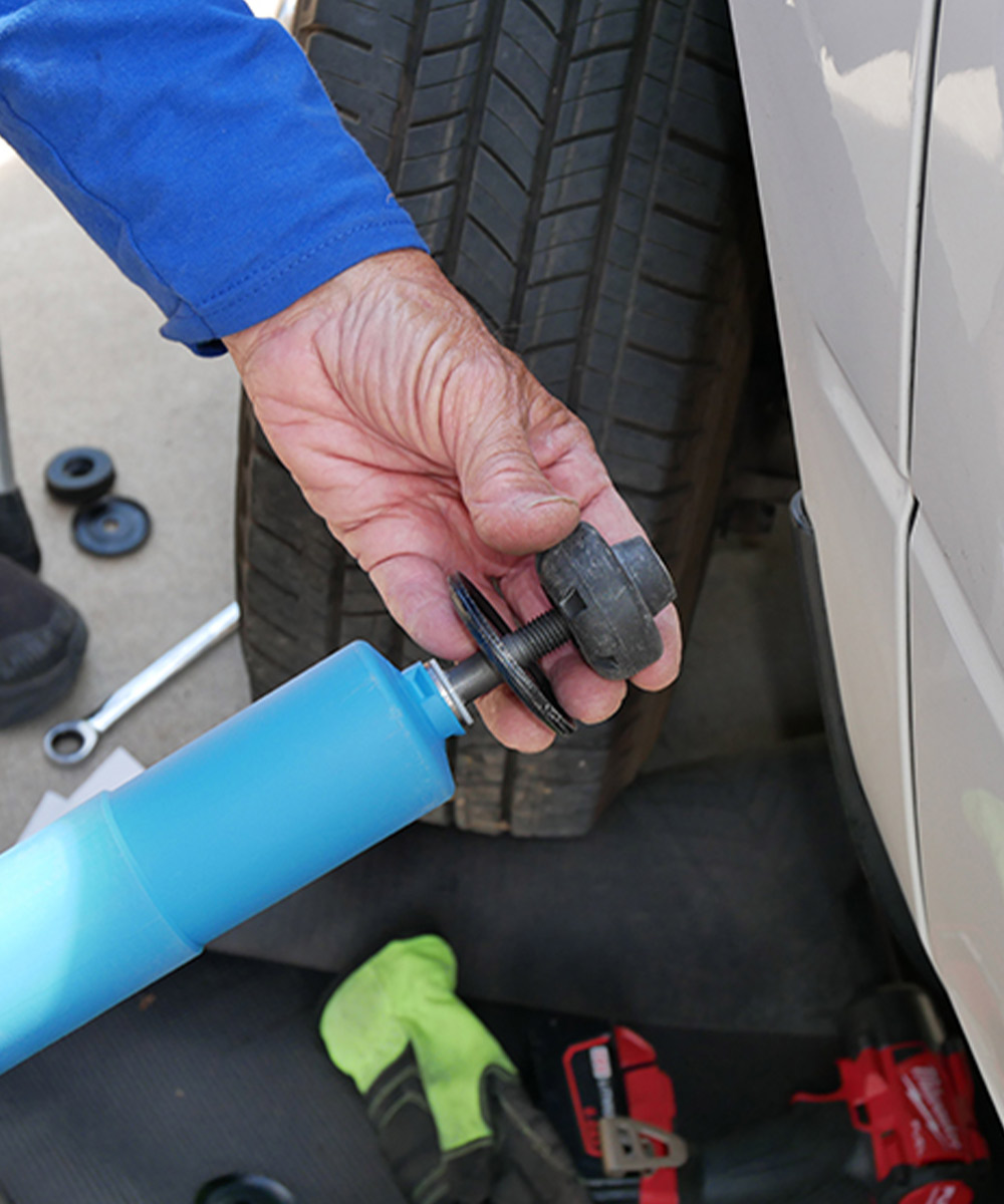 the rubber bushing with the bearing sleeve is placed onto the threads at the top end of the piston rod