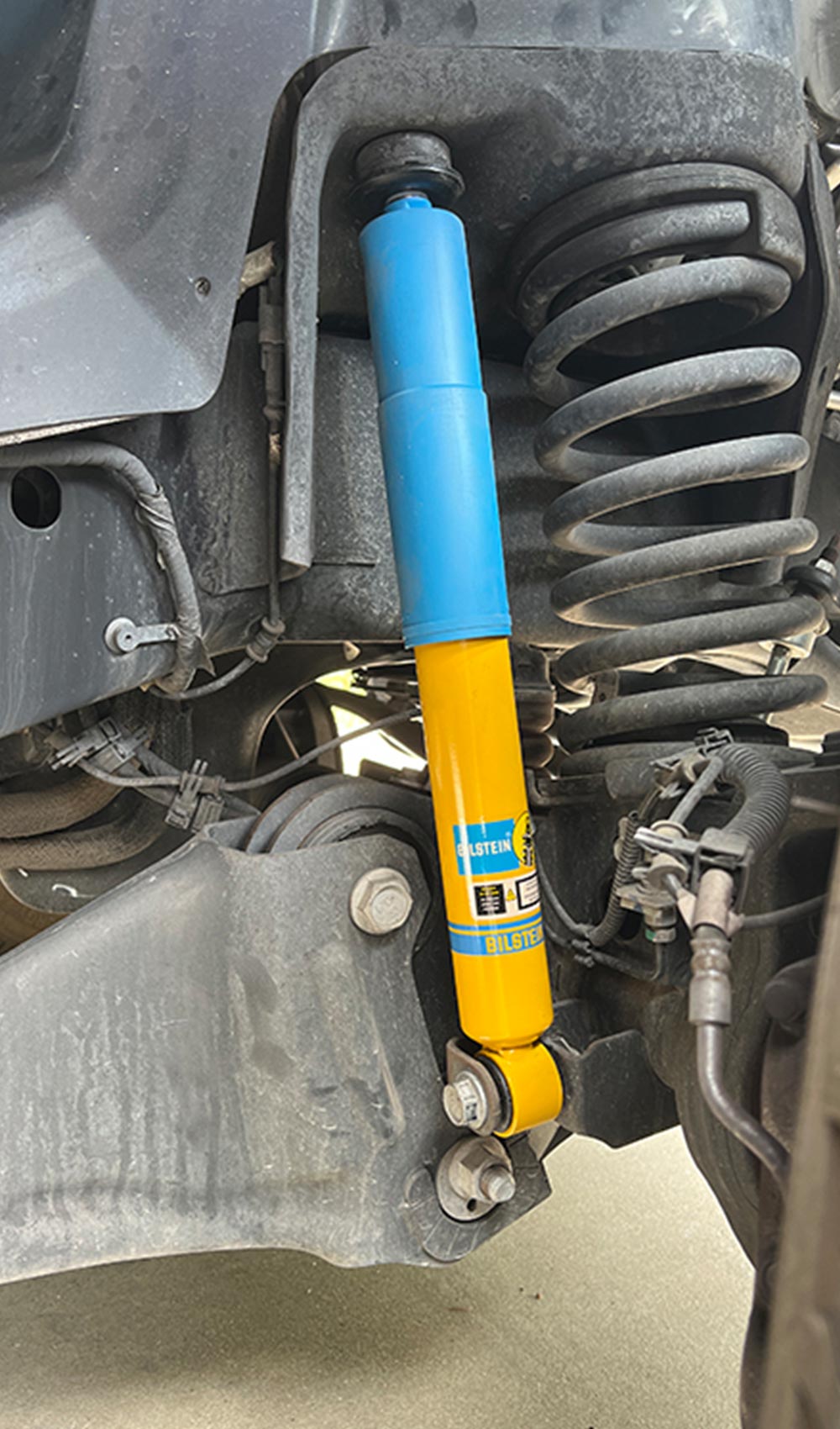 full view of the newly installed vibrant blue and yellow Bilstein shock